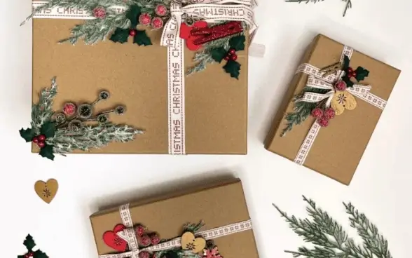 Mehrere weihnachtlich verpackte Geschenke in naturbraunem Kraftpapier auf weißem Hintergrund, dekoriert mit cremefarbenen Bändern, Tannenzweigen, Stechpalmenblättern, roten Beeren, kleinen Holzanhängern und roten Herzornamenten. Auf einem der Geschenkbänder ist mehrfach der Schriftzug 